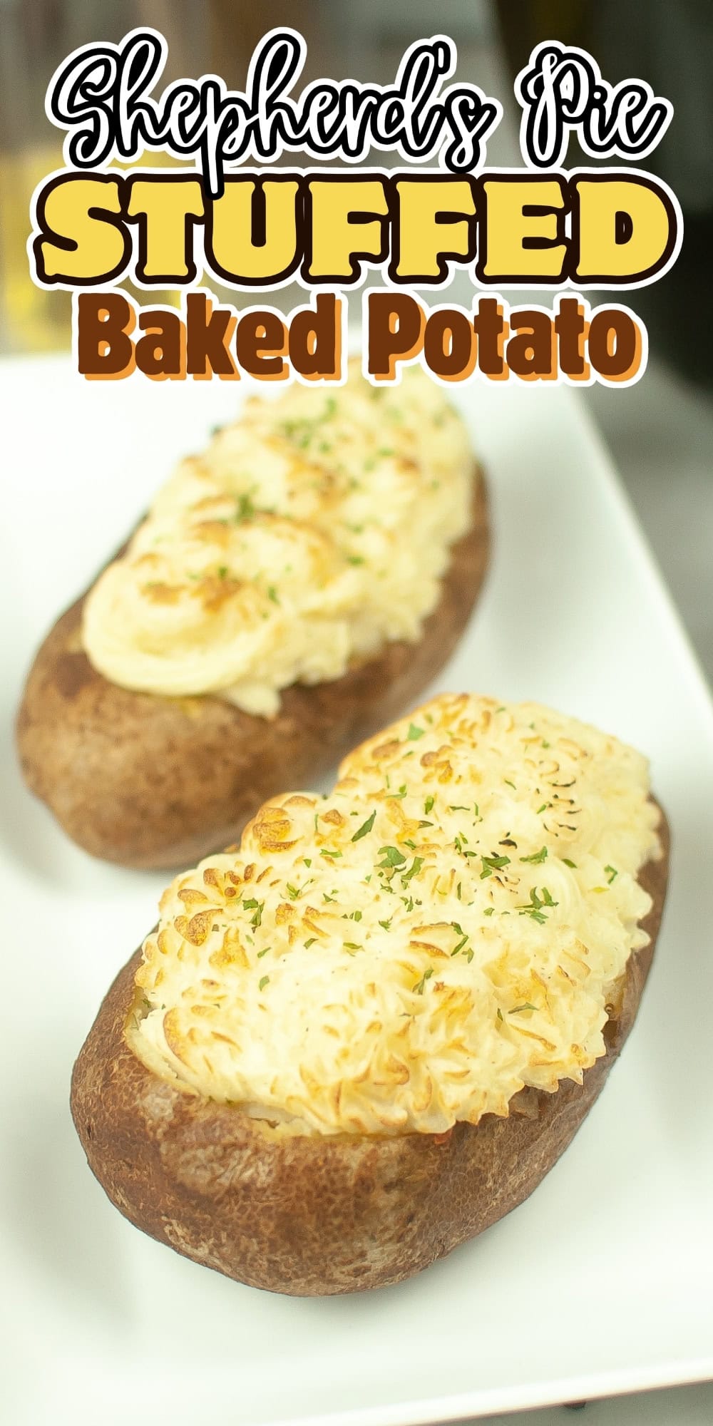Two baked potatoes stuffed with shepherds pie filling on a white plate.