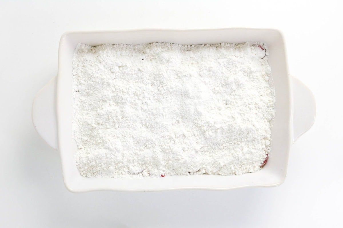 Rectangular baking dish filled with a layer of white flour on top.