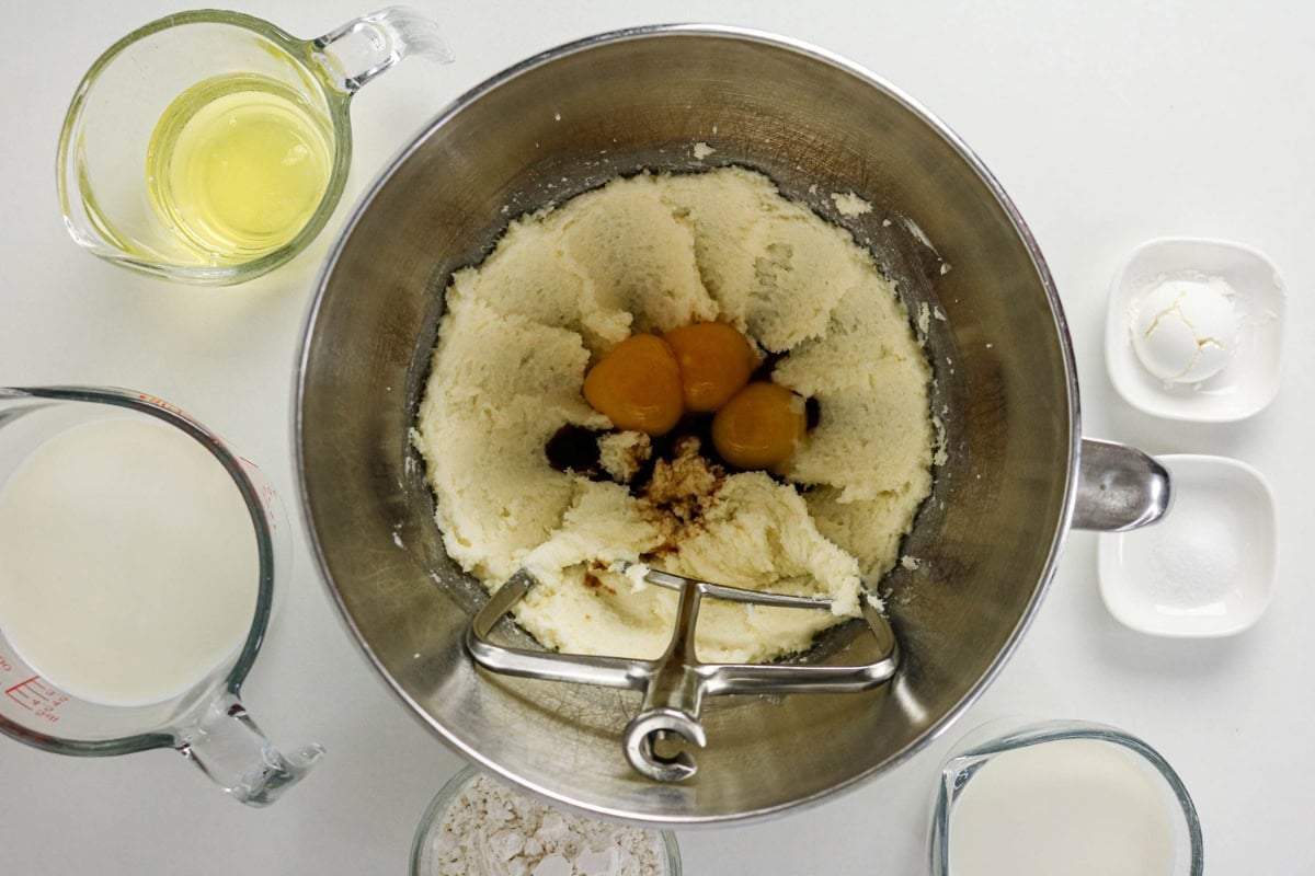 Eggs, milk, flour, sugar, and baking powder, about to be mixed in a stand mixer.