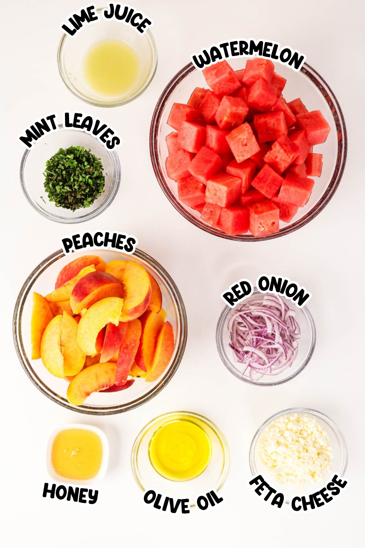 Bowls with watermelon, peaches, mint, onion, feta, honey, oil, and lime juice.