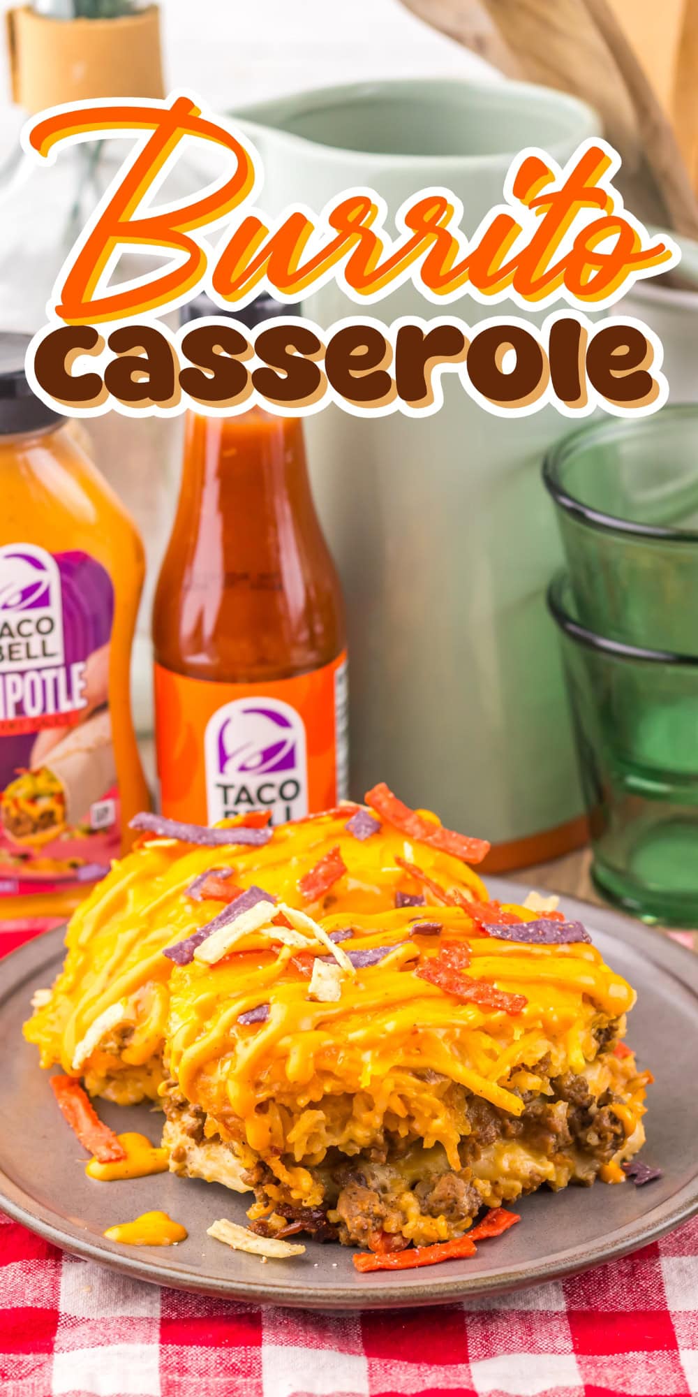 Burrito casserole on a plate with cheese, sauces, and colorful tortilla strips.