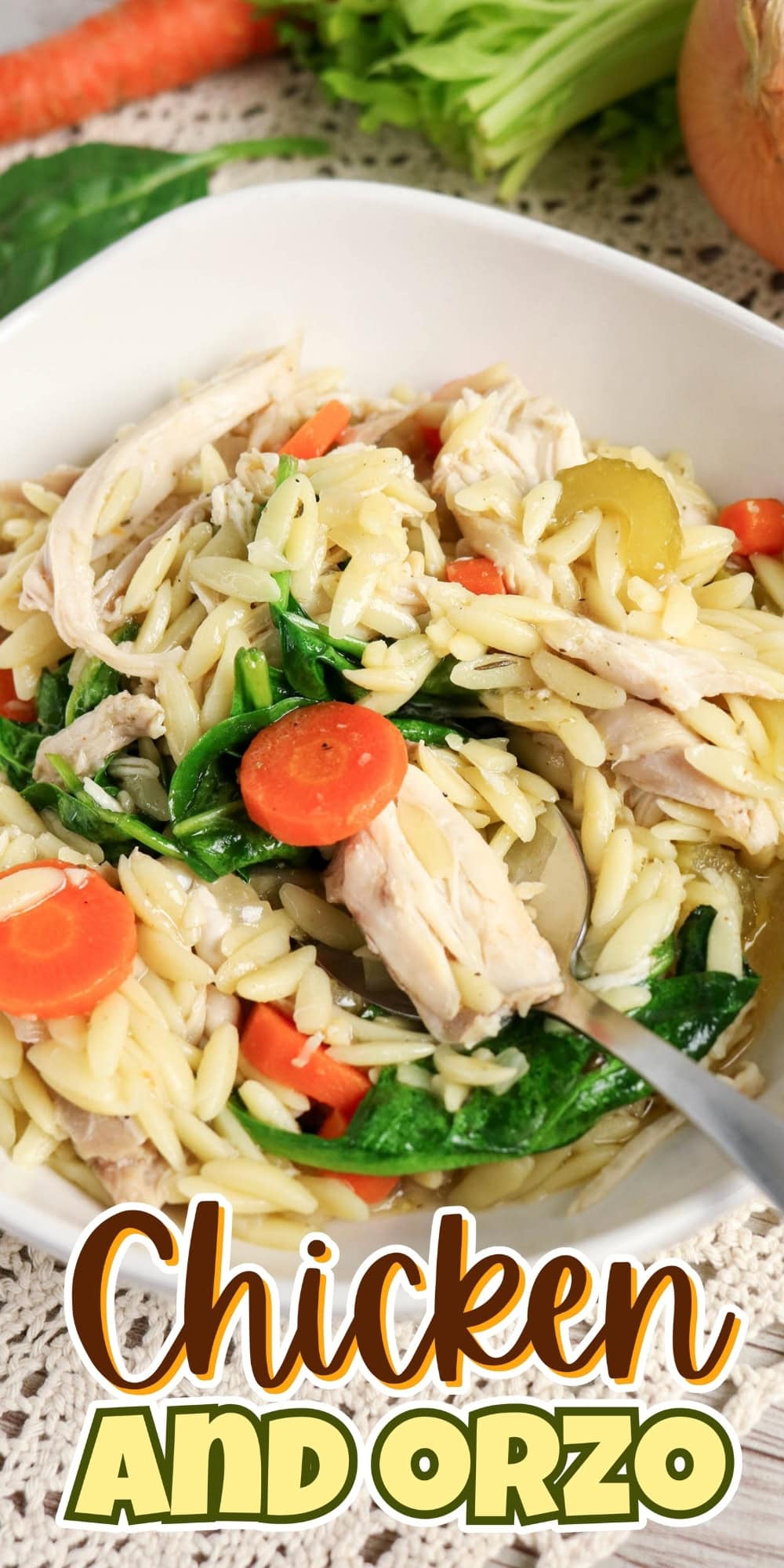 Bowl of chicken, orzo pasta, carrots, and spinach with a fork.