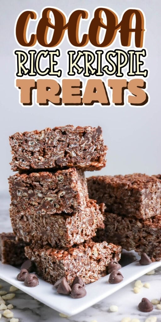Stacked cocoa rice krispie treats on a plate with chocolate chips nearby.