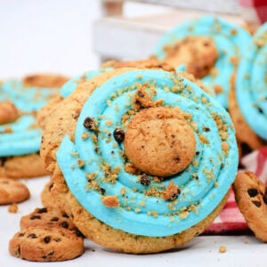 Cookie with blue icing, chocolate chips, and a mini cookie on top.