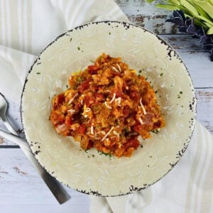 A plate of Spanish rice topped with shredded cheese.
