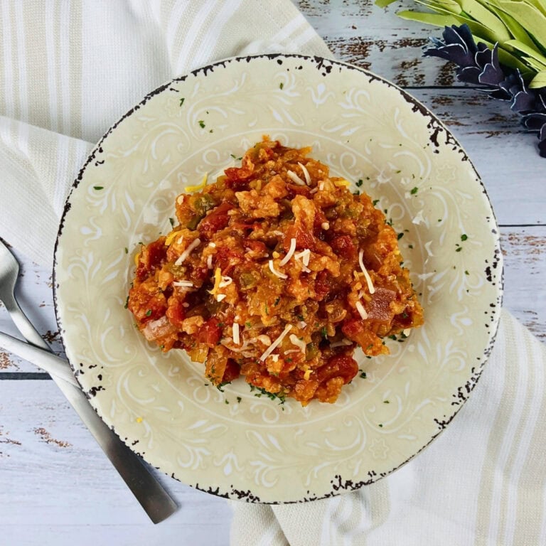 A plate of Spanish rice topped with shredded cheese.