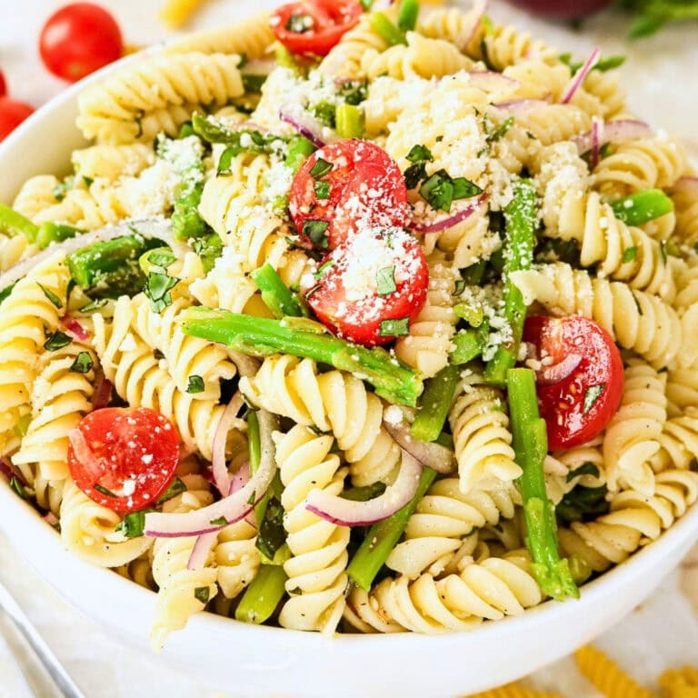Asparagus Pasta Salad with rotini, tomatoes, red onions, and grated cheese.