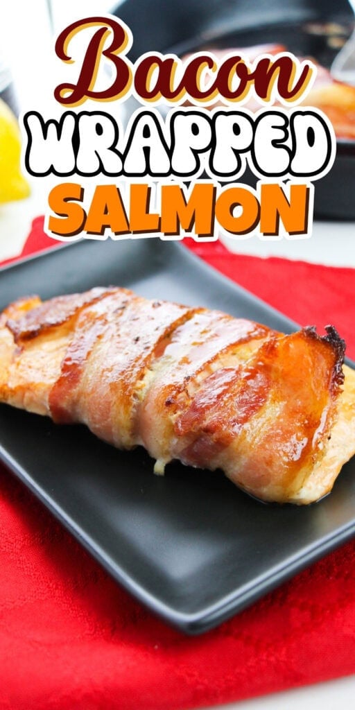 Bacon-wrapped salmon fillet served on a black plate with red napkin.