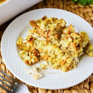 A serving of baked stuffing on a white plate, shown close up.