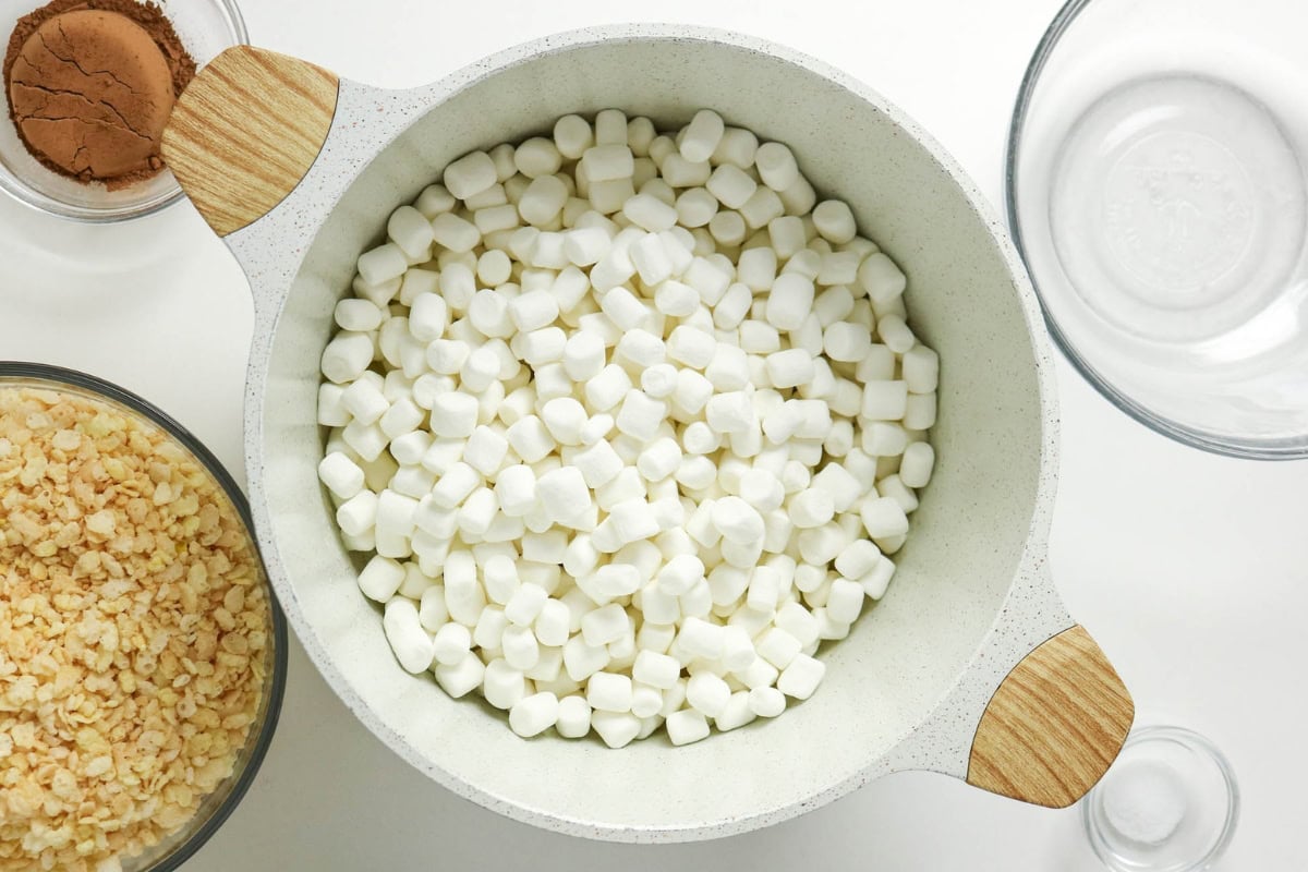 White bowl filled with mini marshmallows, surrounded by bowls with ingredients.
