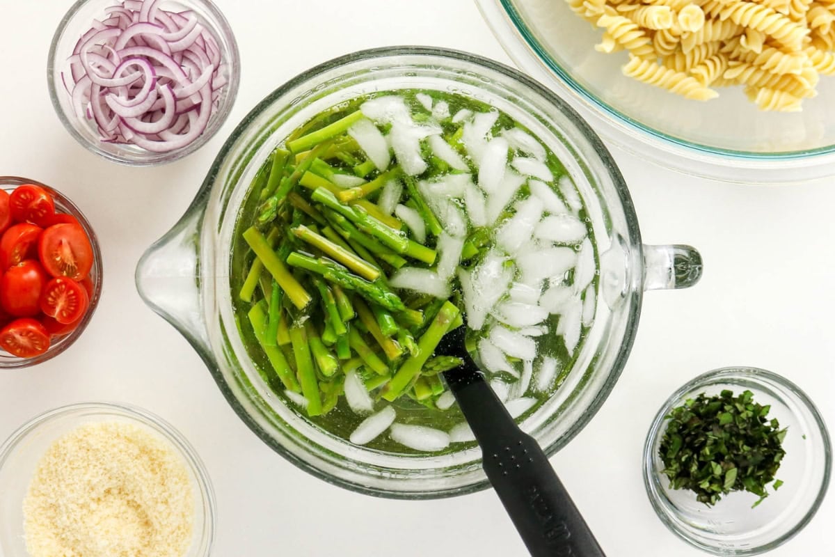 Asparagus chills; pasta, tomatoes, onions, cheese, and herbs included.