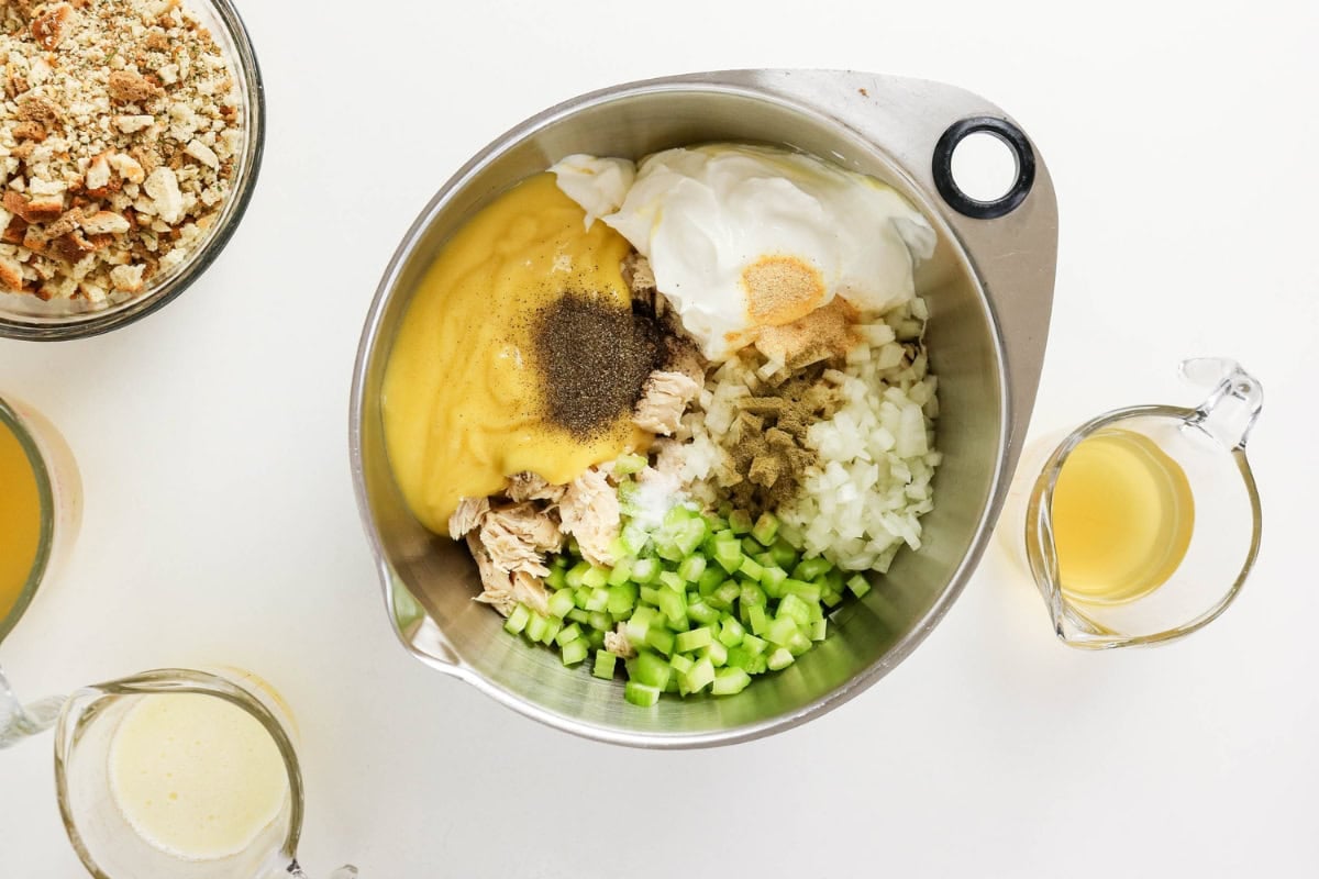 Chicken, celery, onion, soup, mayo, spices; broth and crumbs nearby.