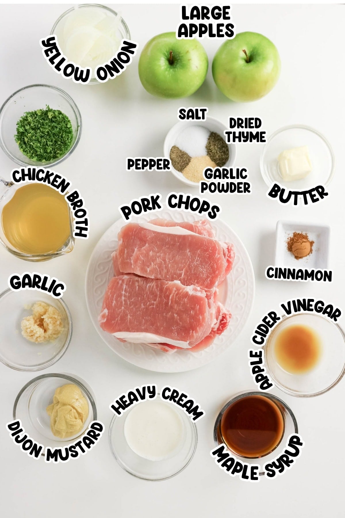 Ingredients for pork chops recipe arranged in bowls on a white surface.