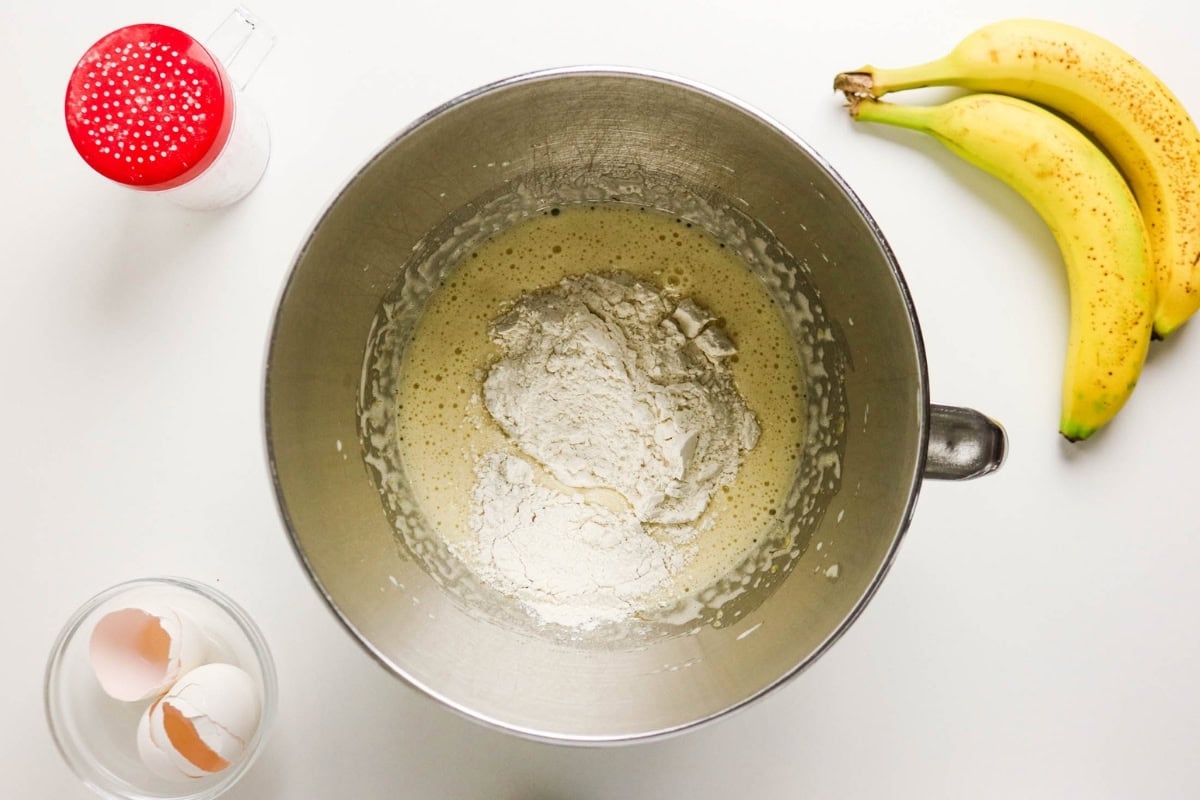 Bananas, flour, eggs, sugar, and salt are ready to make banana bread batter.