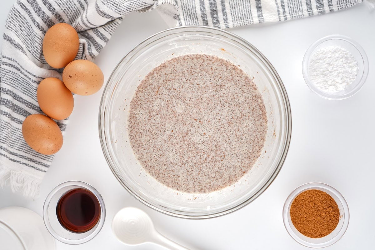 Cream, eggs, vanilla, and cinnamon mixture in a bowl.