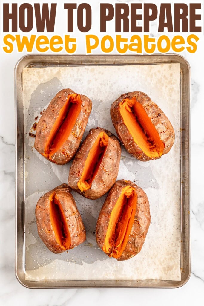Five baked sweet potatoes split open on a parchment-lined baking sheet.