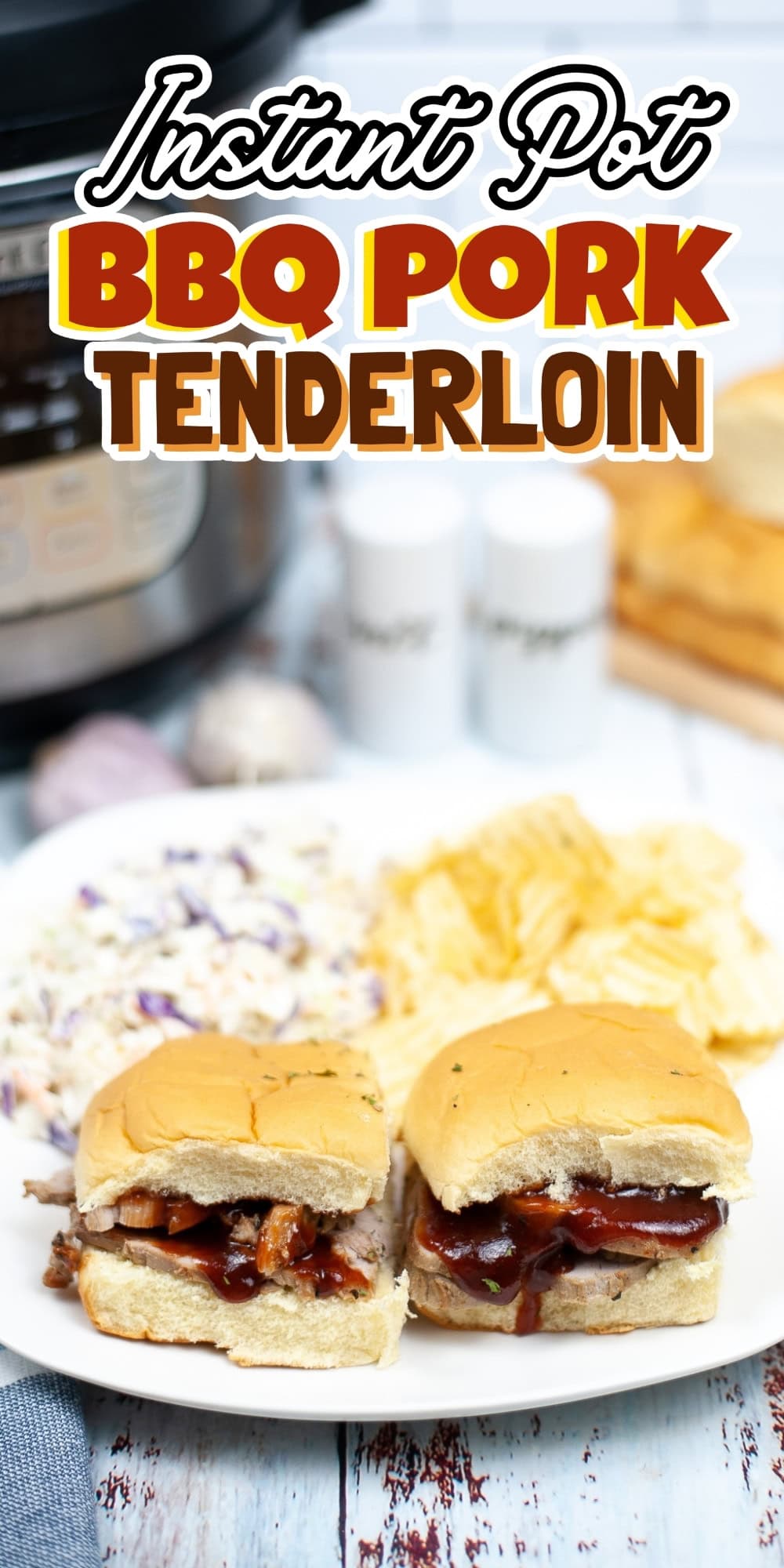 Two BBQ pork sliders with chips and coleslaw on a plate, Instant Pot behind.