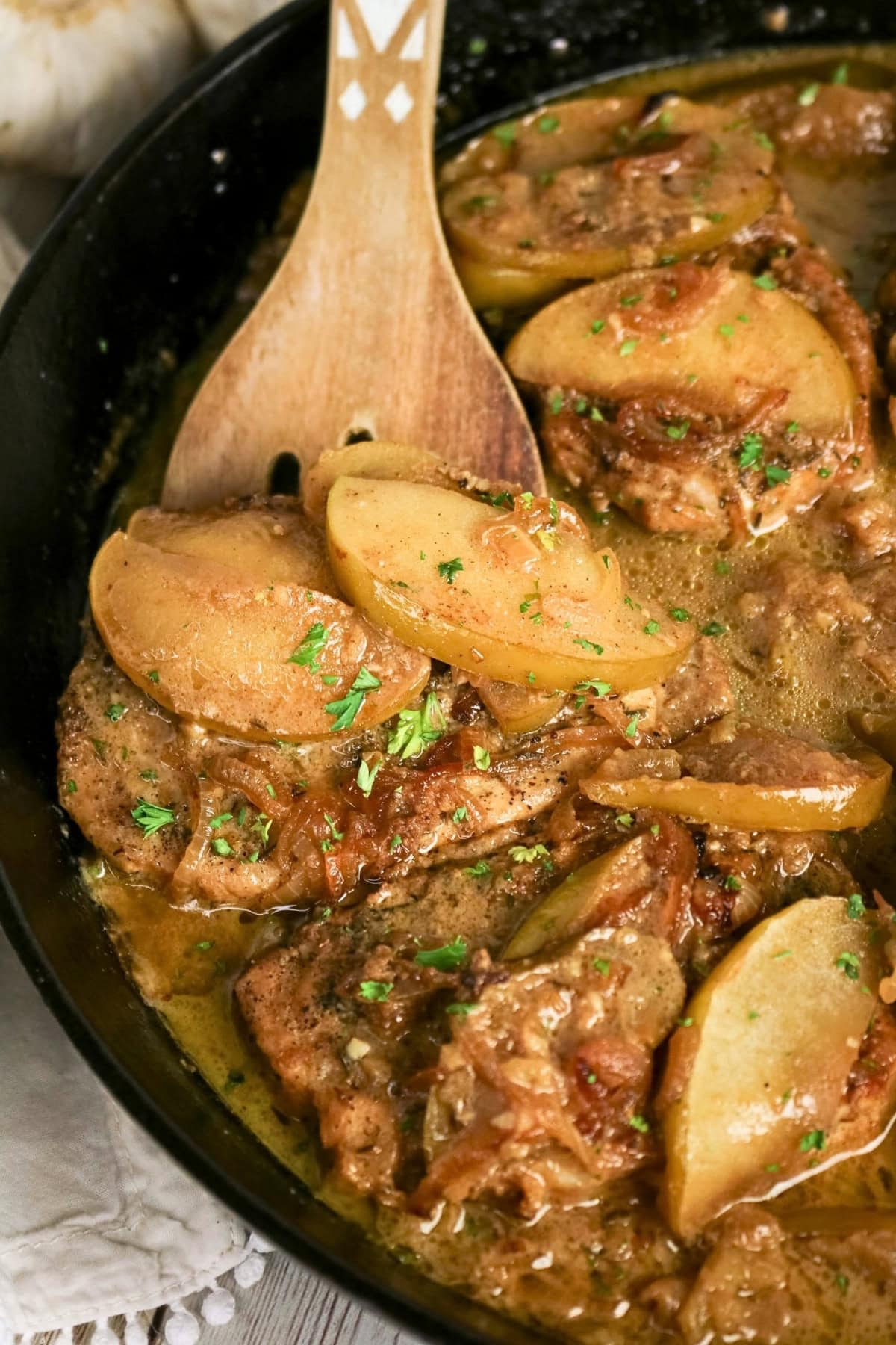 Skillet-seared pork chops with sliced apples and onions in a savory sauce.