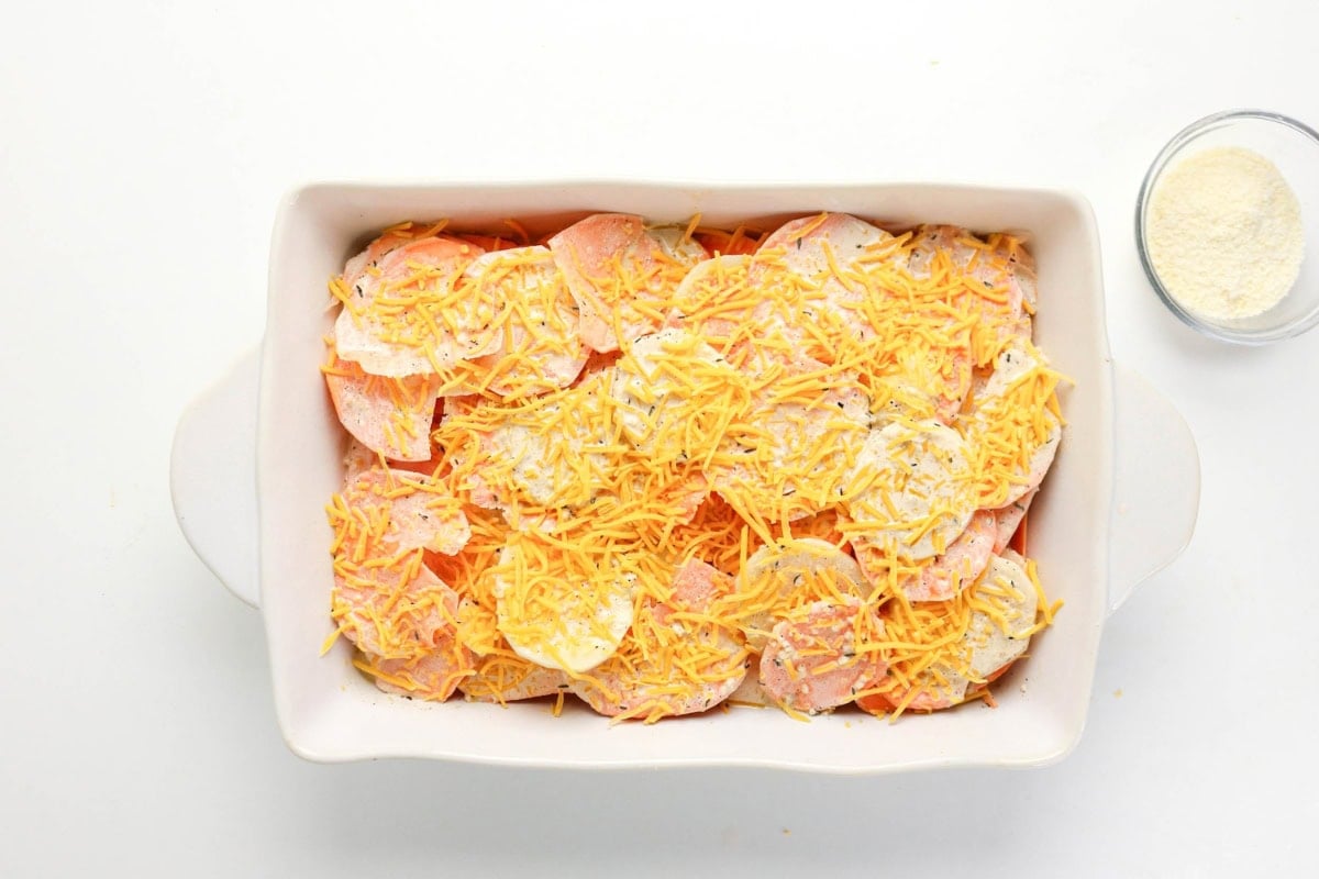 Sliced potatoes with shredded cheddar cheese, ready to bake.