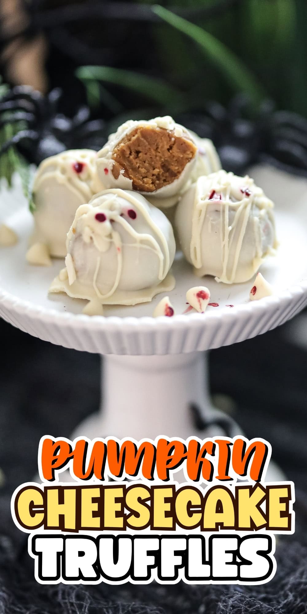 Four white chocolate pumpkin cheesecake truffles on a white cake stand.