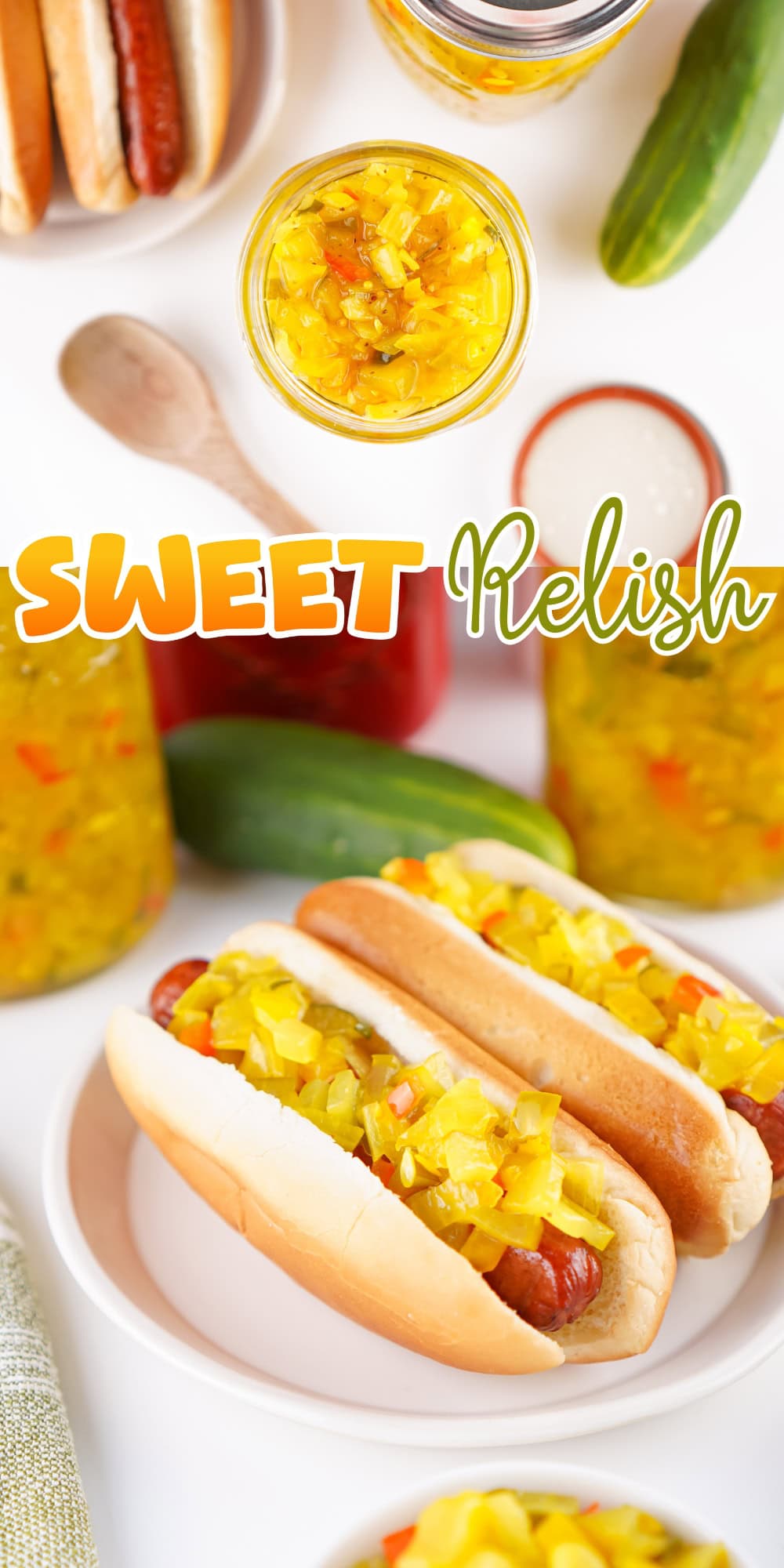 Hot dogs topped with sweet relish, surrounded by jars and fresh cucumbers.