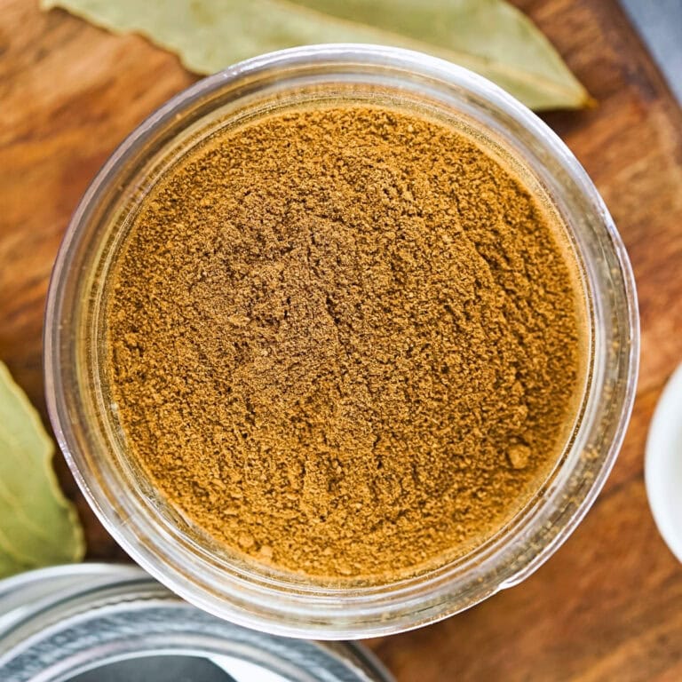 Top-down view of a glass jar filled with brown spice powder.