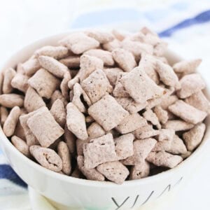 A bowl of chocolate square cereal.