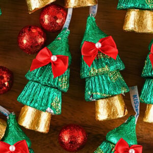 Chocolate Hersheys Kisses wrapped in green and gold foil shaped like trees.