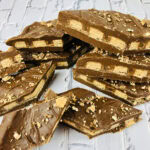 Pieces of chocolate wafer bark topped with crushed cookies.