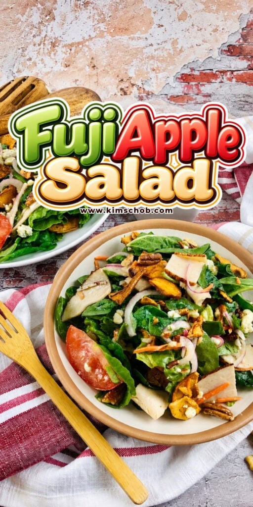 Fuji Apple Salad in a bowl with a wooden fork on a napkin.