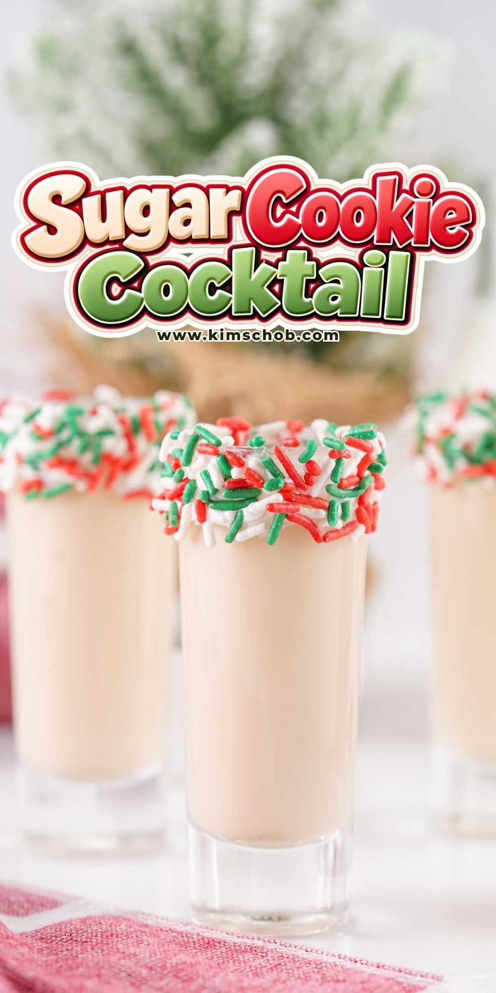 Three shot glasses filled with a beige drink and rimmed with holiday sprinkles.