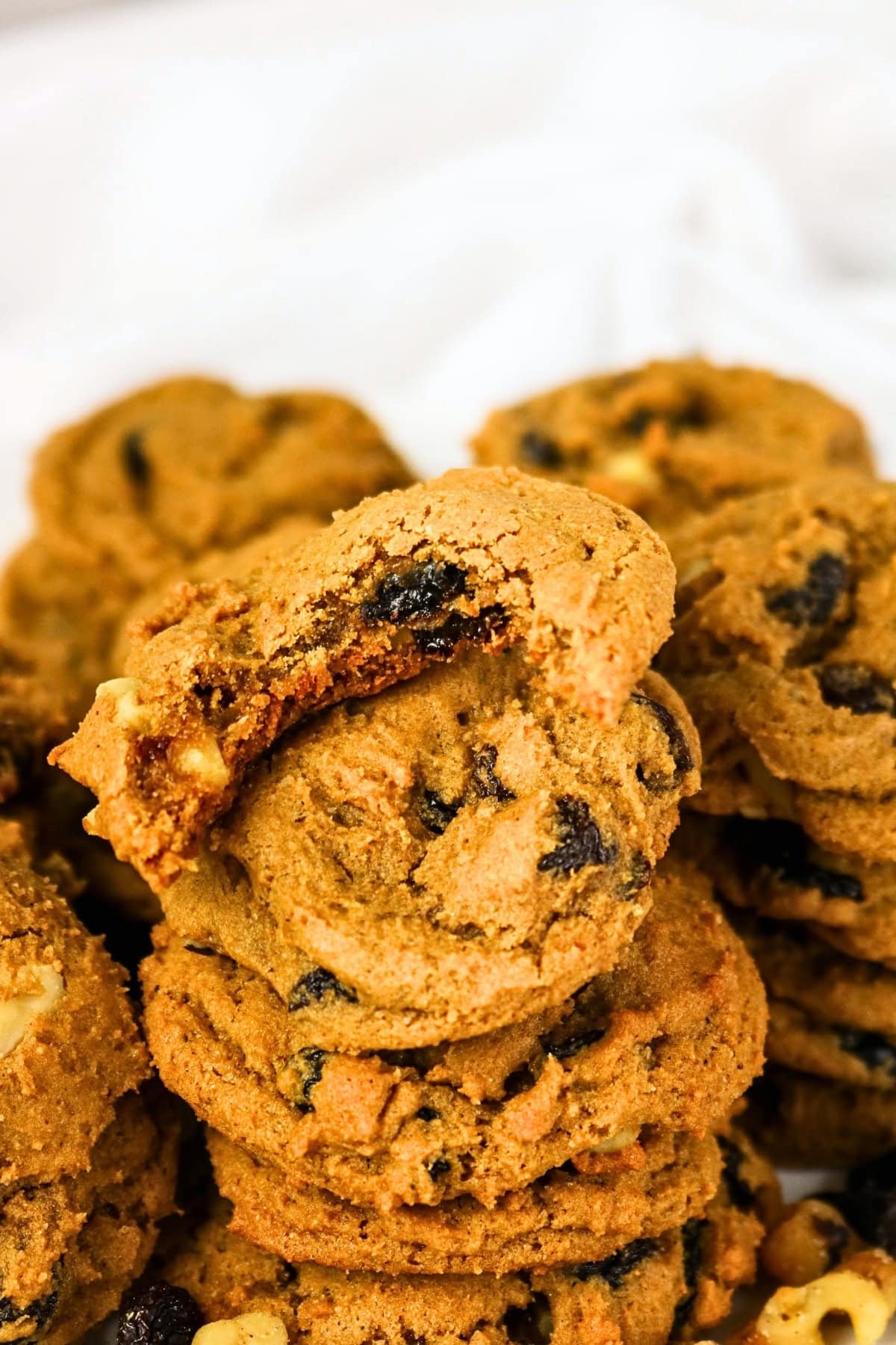 A stack of raisin cookies with one broken in half.