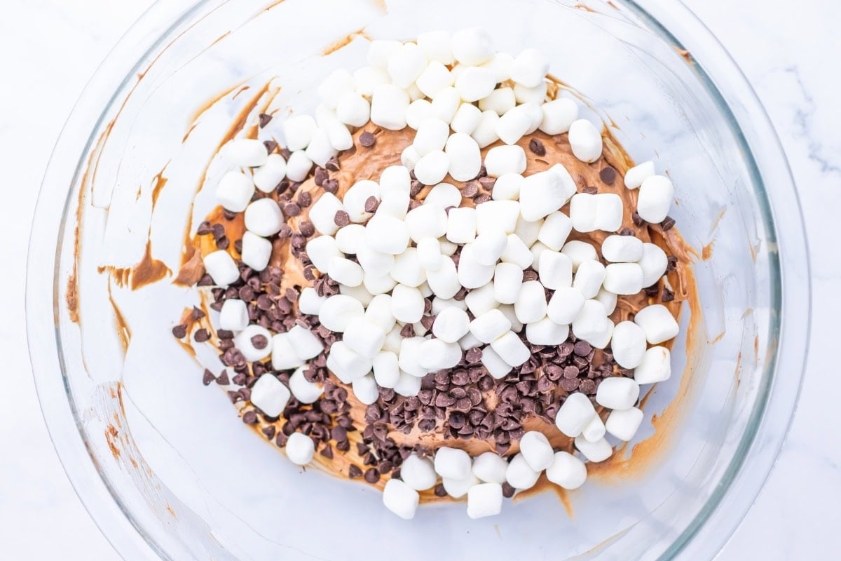 Glass bowl with chocolate mixture, mini marshmallows, and chocolate chips.