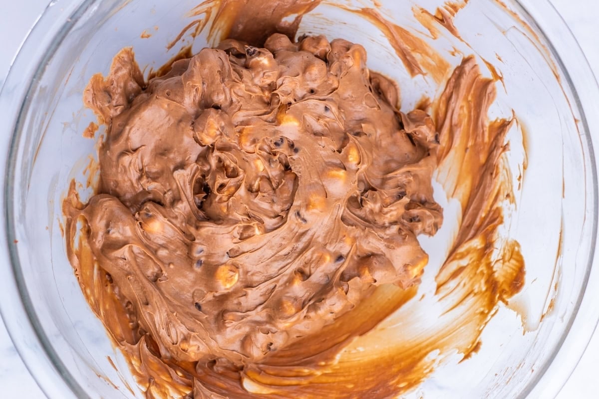 Chocolate cookie dough with mix-ins in a glass mixing bowl.