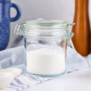 Glass jar with a wire-bail lid filled with white powder.