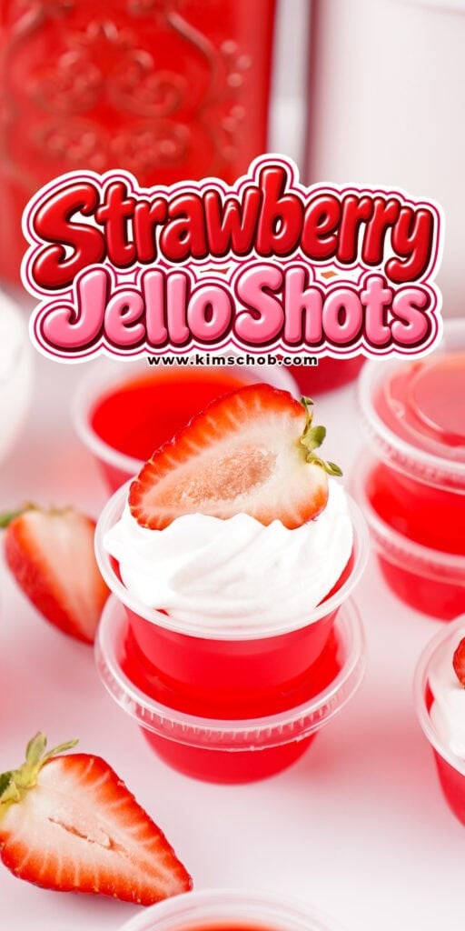 Red strawberry Jello shots topped with whipped cream and a strawberry slice.